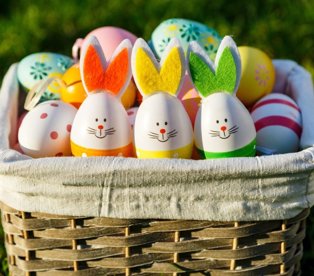 cute easter eggs decorated as easter bunnies sitting in an easter basket